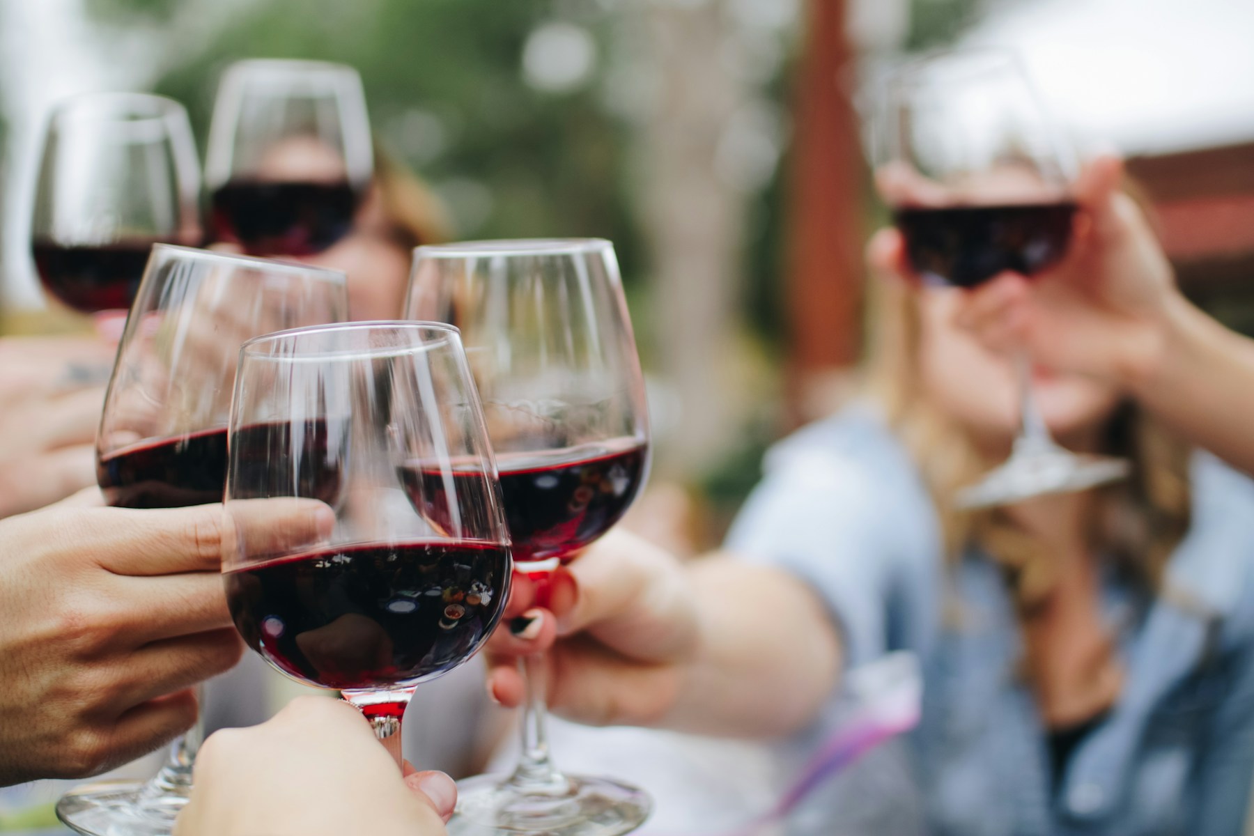 Friends raising glasses of red wine around a table